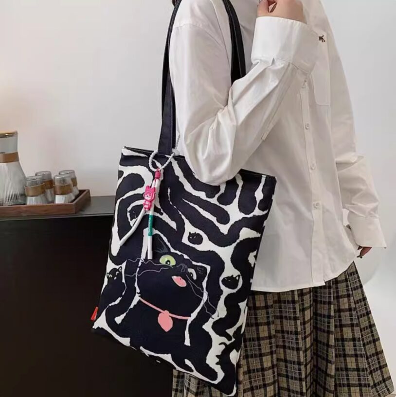 a girl carry black cat tote bag