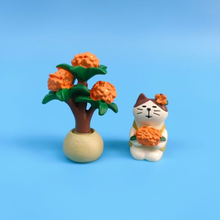 Miniature cat hold fragrant olive under tree